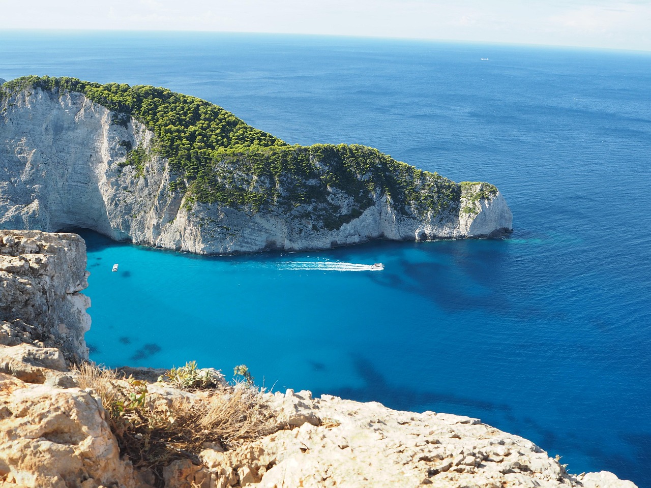 Jachta pluje v Jónském moři, tyrkysová voda, zelené ostrovy v pozadí, bílá plachetnice, slunečný den